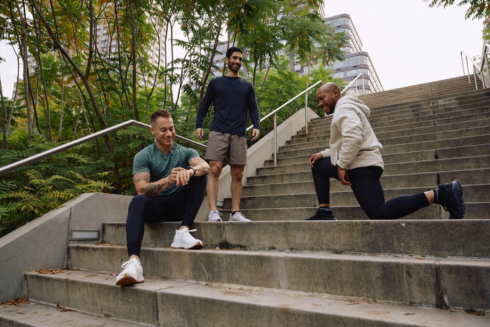 3 men standing on the stairs in workout clothes